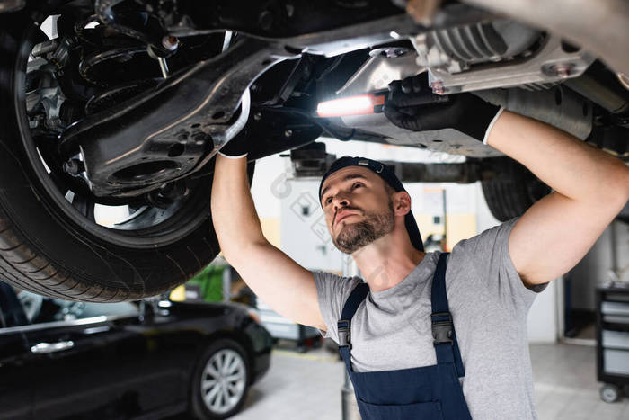 维修站的漂亮技工手持手电筒和修车