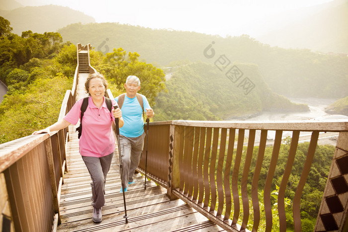 幸福的亚洲高级夫妇在山上徒步旅行