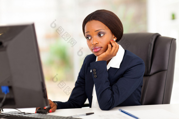 看着在办公室的电脑屏幕的周到非裔美国女商人