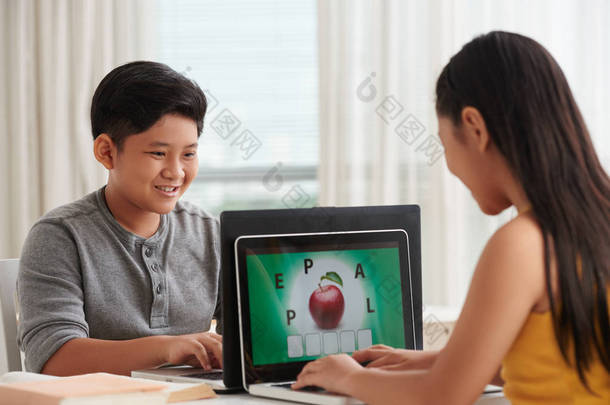 两个亚洲儿童在学校, 女孩使用笔记本电脑, 显示器屏幕与苹果图片 