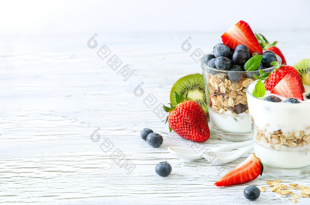 Healthy breakfast with muesli in glass, fresh berries and yogurt