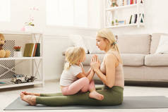 快乐的母亲和女儿拥抱, 而家庭瑜伽课