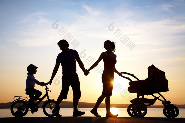 日落大道上散步的幸福家庭