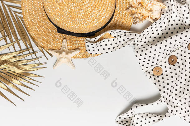 夏天妇女的白色衣服黑色豌豆与天然木制纽扣草帽金棕榈叶壳海星淡淡的背景。平面放置顶部视图复制空间。女子海滩时尚旅游度假.