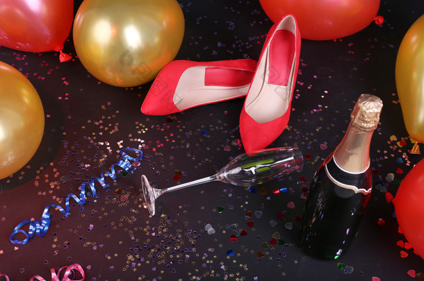 用五彩纸屑、 香槟和气球在地板上的鞋