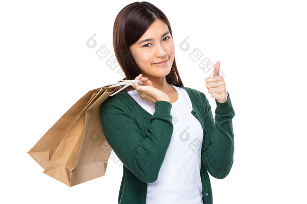女人用购物袋和拇指向上