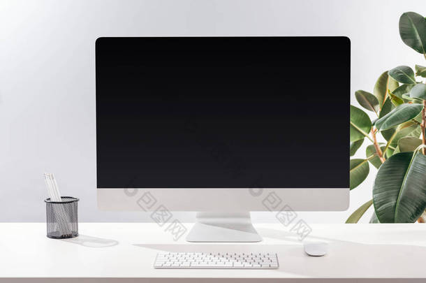 <strong>工作</strong>场所与计算机和文具在白色桌在绿色植物附近在灰色背景