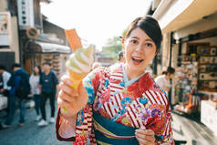 游客体验日本文化, 穿着和服, 尝试京都著名的抹茶冰淇淋。年轻的女孩旅行在日本旅游。亚洲人的脸相机显示甜.