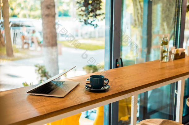 木制咖啡厅柜台的笔记本<strong>电脑</strong>和咖啡杯