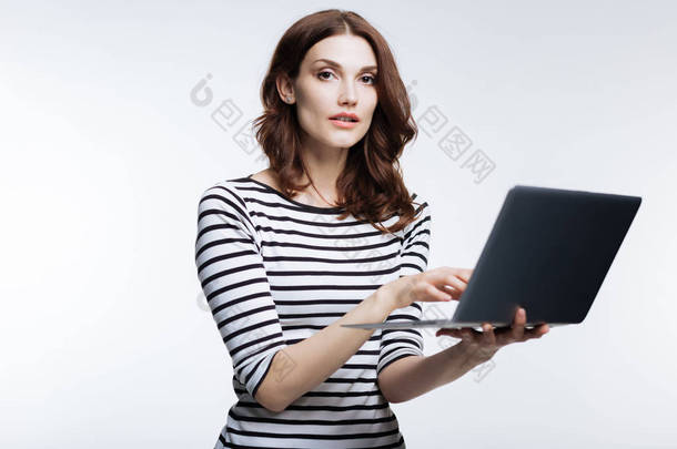 在笔记本电脑上工作的美丽的赤褐色头发的妇女