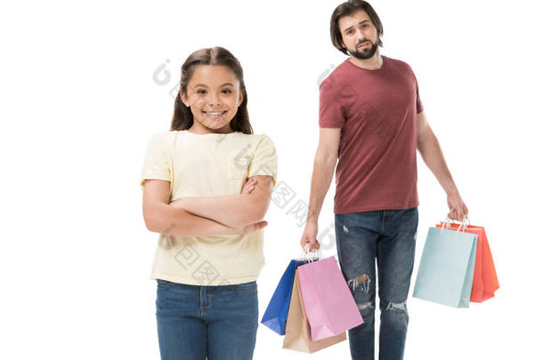有选择的焦点微笑的孩子和疲倦的父亲与购物袋被隔绝在白色