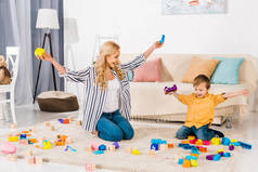 快乐的母亲和儿子在家里玩五颜六色的积木