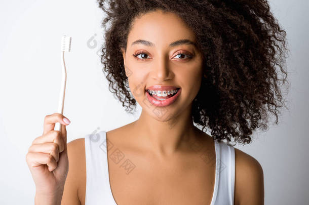 快乐的非洲裔美国女人，带着牙刷，与灰色隔离