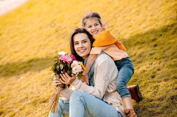 女人带着女儿的手捧花 