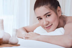在白色床上微笑和获得水疗治疗的迷人年轻亚洲妇女特写