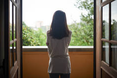 站在阳台上欣赏风景的妇女后视图
