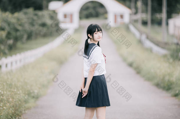 亚洲日本学校女孩服装<strong>的</strong>肖像看公园户外电影复古风格