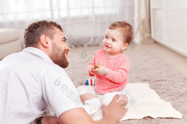 Pleasant young father playing with his child