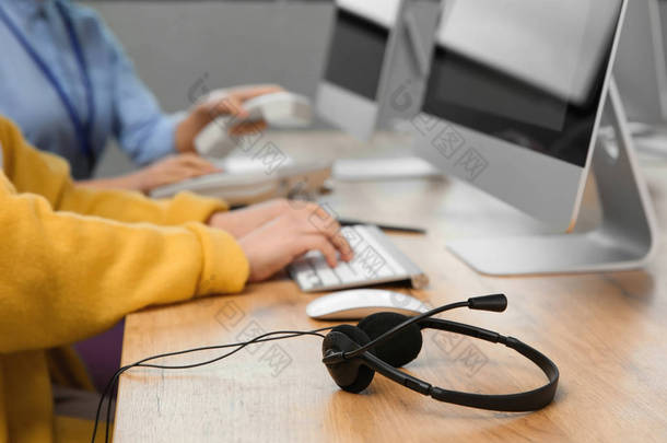 技术支持操作员在办公室餐桌上工作，专注于耳机
