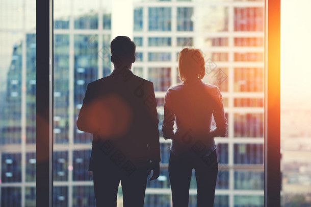 Team of business partners looking out of window