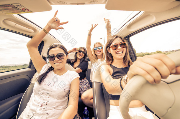 四个女孩在一辆敞篷车开车和乐趣
