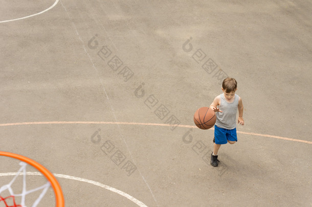 年轻男孩在打篮球带球跑