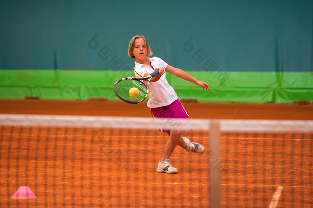 运动员用球拍在网球场上的女孩