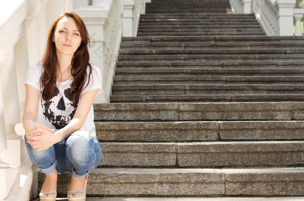 孤独的年轻女子坐在<strong>楼梯</strong>上