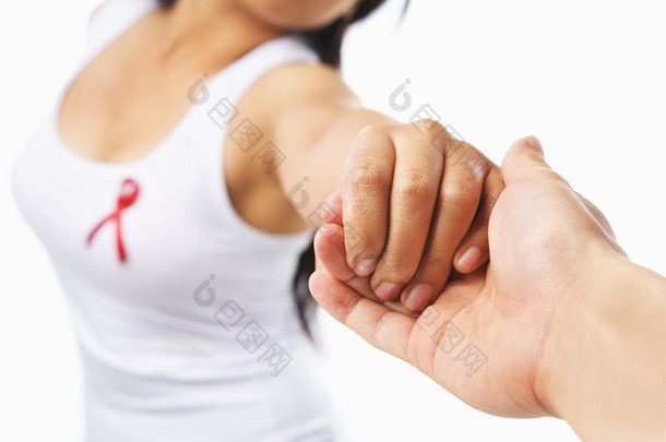 女人握着的手给支持艾滋病事业或乳房会在墨西哥海滩