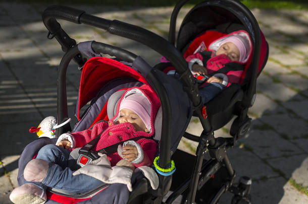 睡在双人婴儿车双胞胎婴儿