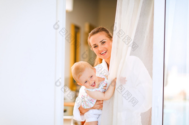 浴袍和宝宝望着来回的微笑母亲的画像