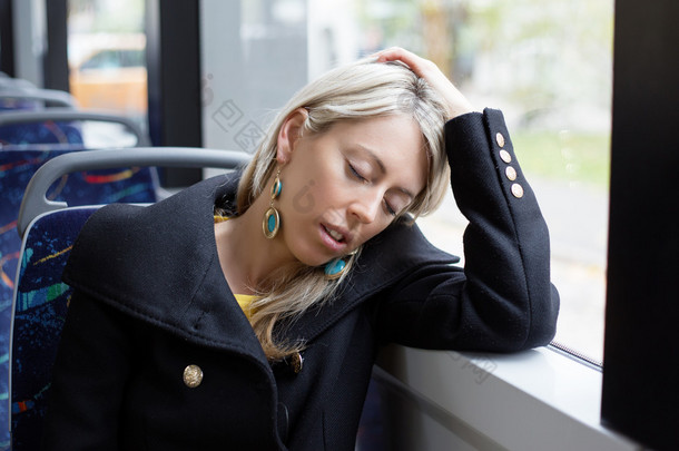 疲惫的女子睡在骑马时，在公共交通工具<strong>上班</strong>