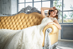 在优雅的昂贵室内的豪华婚纱美丽的黑发新娘的照片
