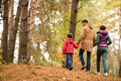 家人行走在秋天的树林