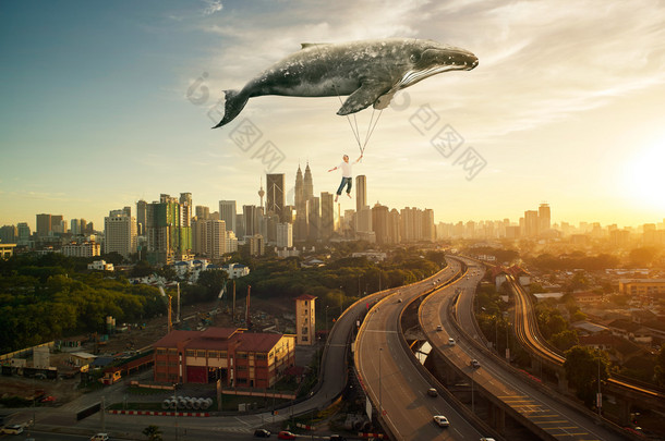 人和大鲸鱼飞过城市景观