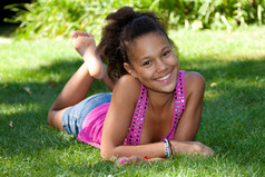 年轻的黑少女女孩躺在草地上