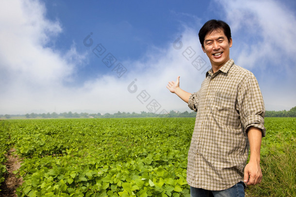 快乐亚洲农夫显示他的农场