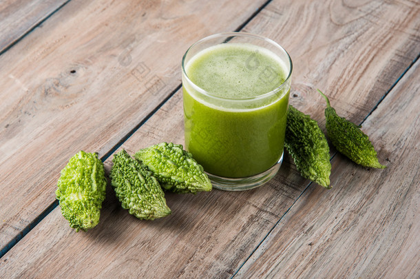 在蔬菜切片，karela 果汁或苦瓜汁一杯绿色 momodica 的草药汁