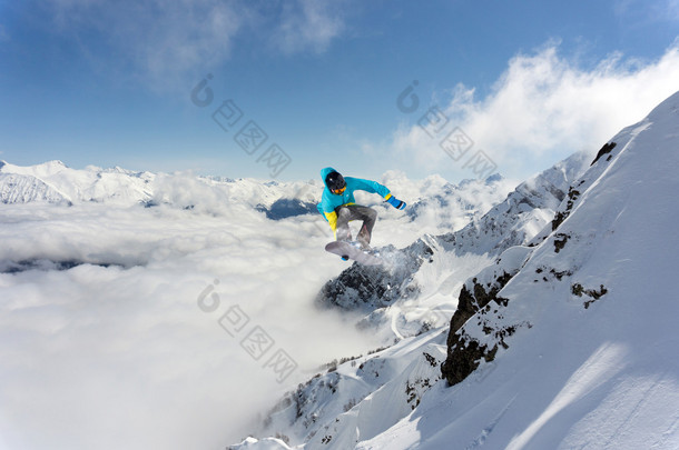 滑雪板骑手跳跃于群山之巅。极端的滑雪随心所欲的运动.