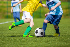 培训及足球比赛之间青年足球队。玩足球游戏的年轻男孩.