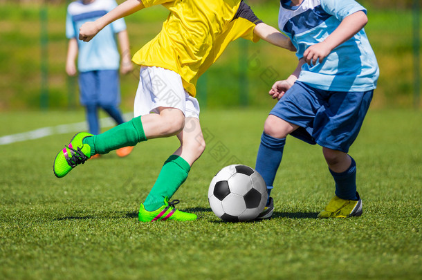 培训及足球比赛之间青年足球队。玩足球游戏的年轻男孩.