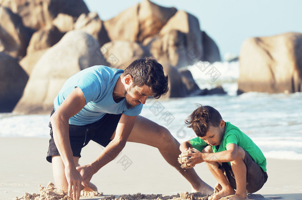 幸福的家庭，在海滩玩，父亲带儿子散步海洋海岸上