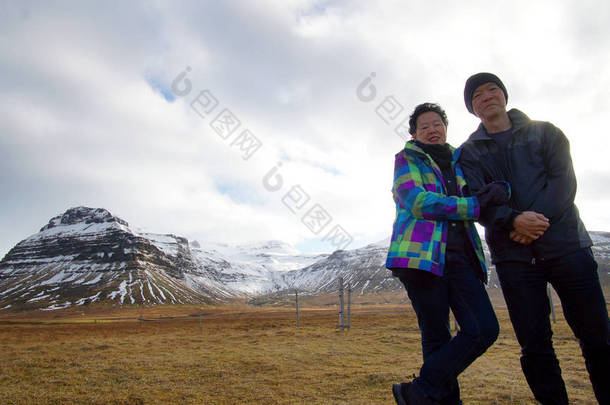 亚洲的年长夫妇享受<strong>周年</strong>的欧洲之旅。冰岛火山景观山与雪惊人的视图