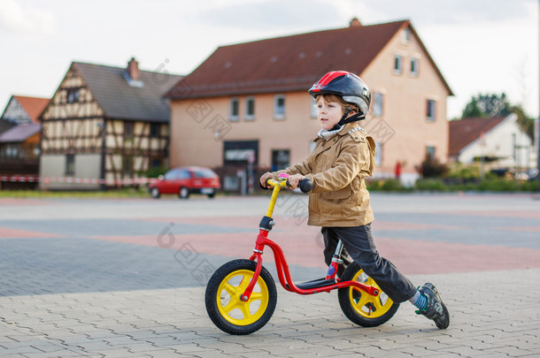 蹒跚学步的小男孩开心和骑他的自行车 