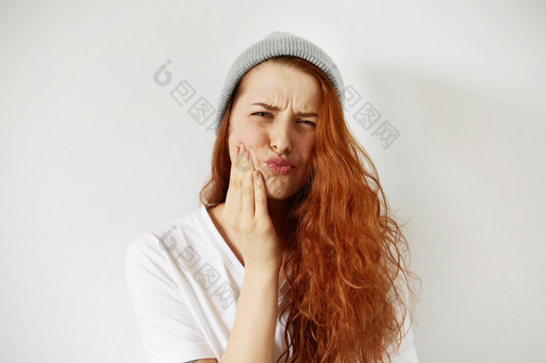woman pressing cheek with painful expressio