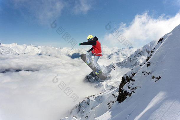 滑雪板骑手跳跃于群山之巅。极端的滑雪随心所欲的运动.