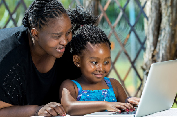 非洲母亲和儿童看笔记本电脑.