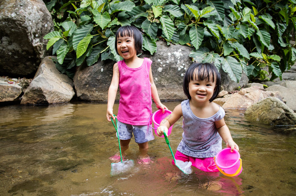 亚洲小的中国女孩在小河里玩耍 