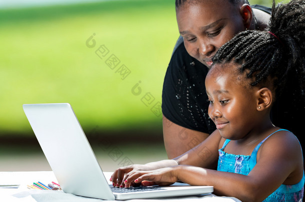 帮助孩子在笔记本电脑上的非洲母亲.