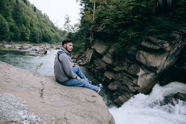 男人坐在美丽的山河